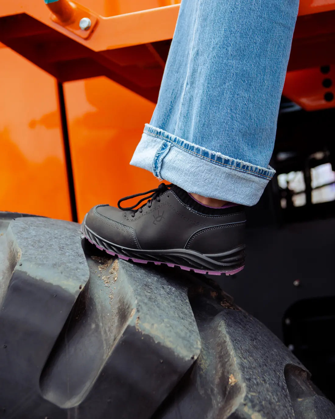Zapato de seguridad Tucana apoyado en la llanta de una máquina